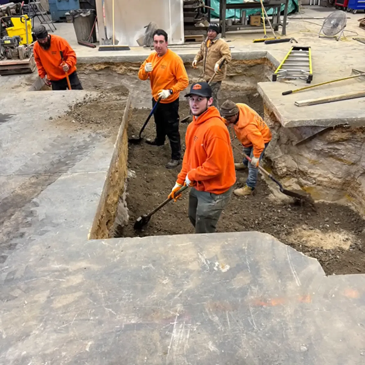 Papaneri and Sons crew hand digging with shovels beside a broken concrete slab in Cherry Hill, New Jersey