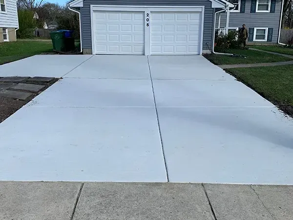 New concrete driveway pitched from a two car garage down to the public sidewalk in Cherry Hill, New Jersey