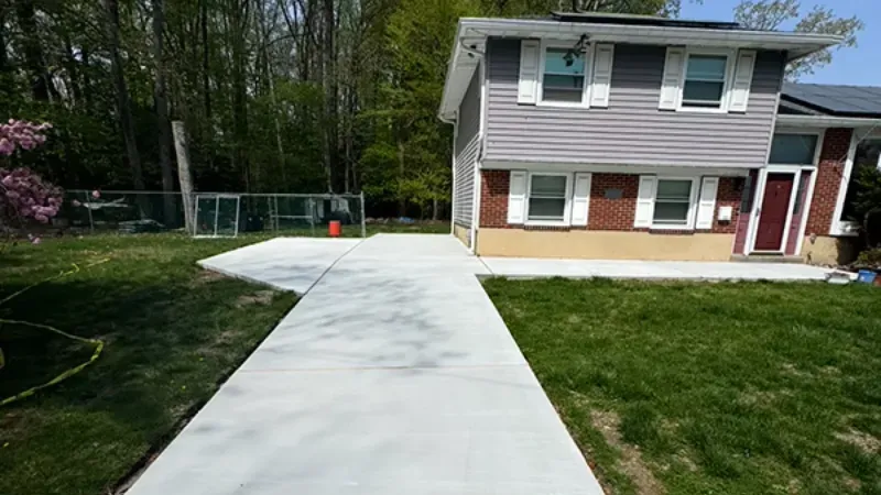 Long concrete driveway sloping down from a split level home to the street in Cherry Hill, New Jersey