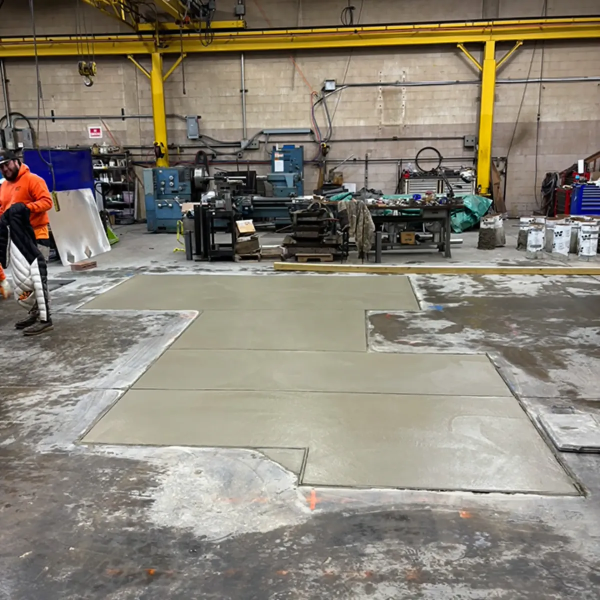 Freshly poured interior concrete floor slab inside a building, screeded flat and ready to finish