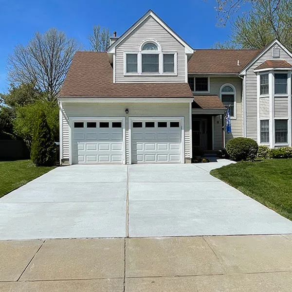 Finished two-car concrete driveway in front of a two-story home, poured by an Echelon, NJ area concrete contractor