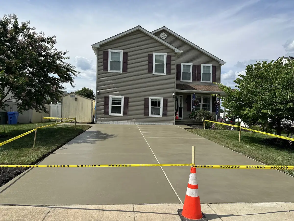 Freshly poured concrete driveway taped off in front of a two-story home, poured by a Haddonfield area concrete crew