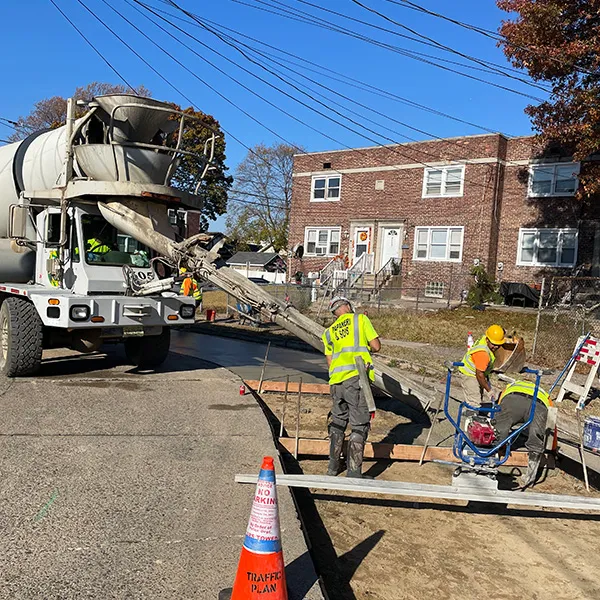 Papaneri crew placing concrete from a mixer truck on a street pour, the kind of access planning Westmont jobs need