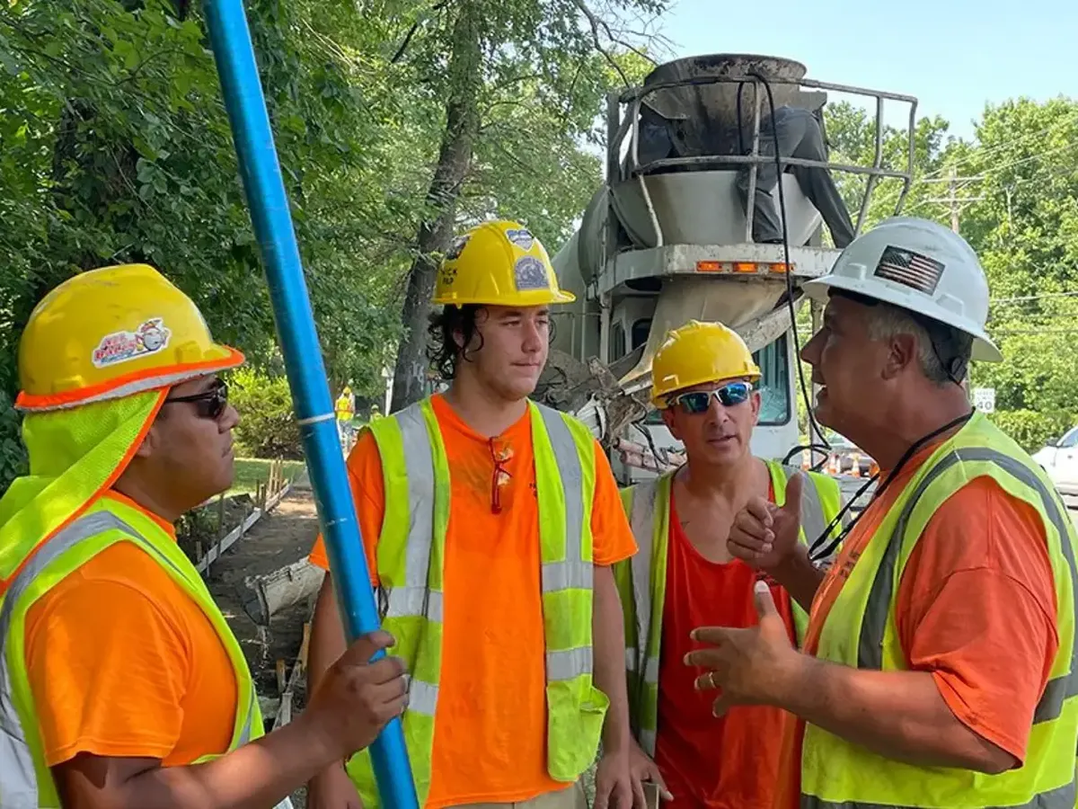 Papaneri & Sons crew in hard hats talking beside a ready-mix truck on a South Jersey concrete pour
