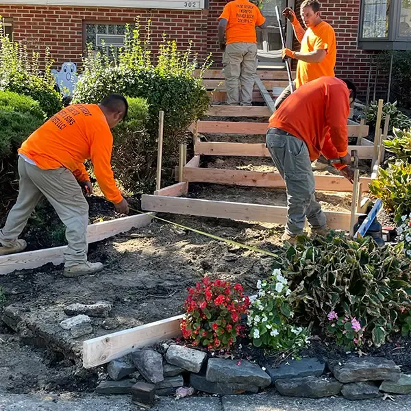Concrete crew setting wood forms to rebuild a set of failed front steps at a home